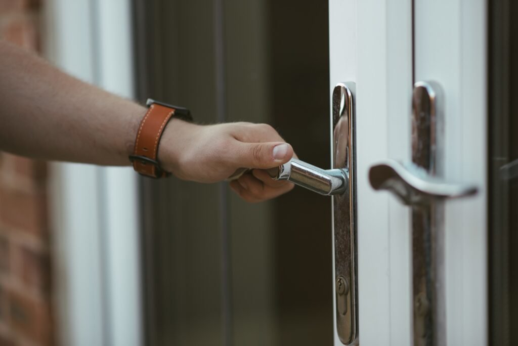 Persona abriendo la puerta de su casa.
